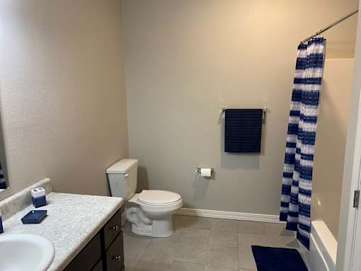 a bathroom with a toilet and a shower and a sink