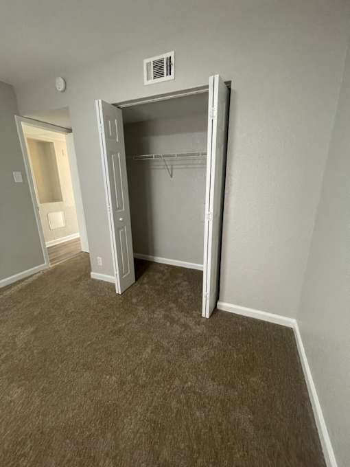 A room with a closet and a doorway.