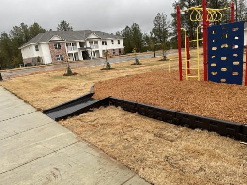 a childrens play area with a wooden deck and a blue and yellow playset