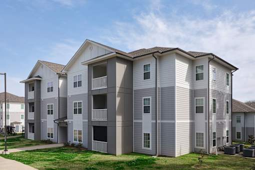 A large apartment building with multiple balconies and windows.