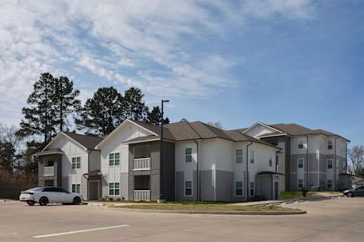 A row of townhouses with a car parked in front.