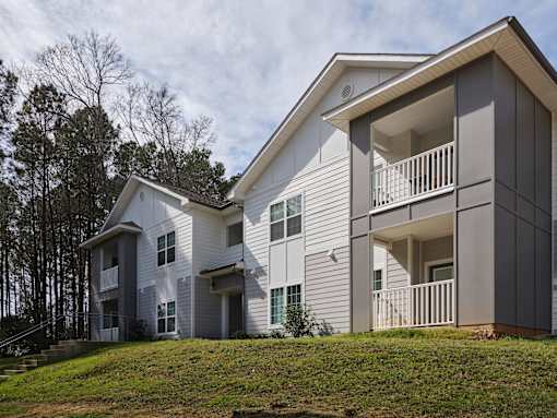 A modern two-story house with a balcony on the upper floor.