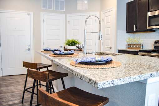 A kitchen with a marble countertop and a wooden chair at Silver Oaks Apartments, Gonzales, Louisiana