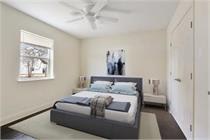 A bedroom with a bed and a ceiling fan.