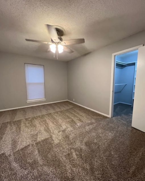 an empty room with a ceiling fan and a closet