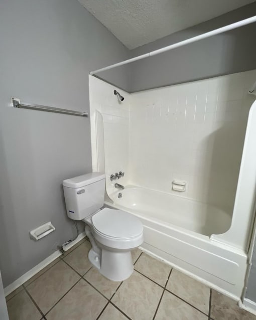 an empty bathroom with a toilet and a tub