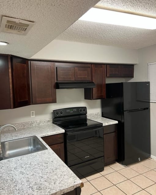 a kitchen with black appliances and granite counter tops
