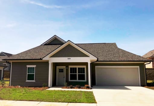 a house with a garage door and a lawn