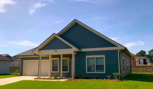 a blue house with a lawn in front of it