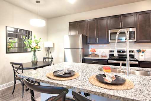 A kitchen with a granite countertop and a black chair at Silver Oaks Apartments, Gonzales, LA 70737