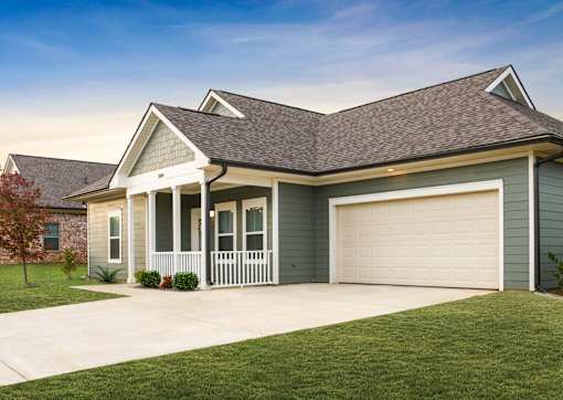 A house with a grey roof and a white garage door.