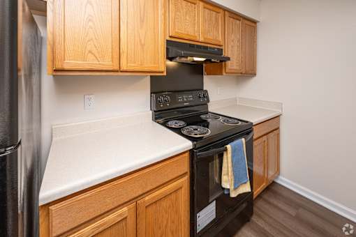 A black stove top oven with a blue towel hanging on it.