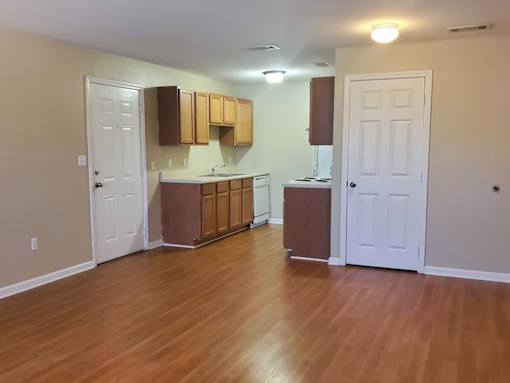 A kitchen with wooden floors and white walls.