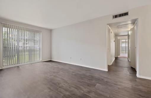 A room with a sliding door and a window with blinds.