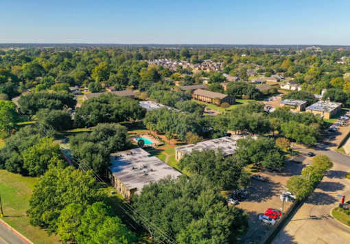 A bird's eye view of a green campus with buildings and trees.