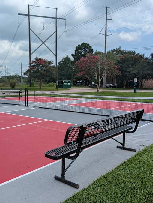 A black bench sits on a red track.