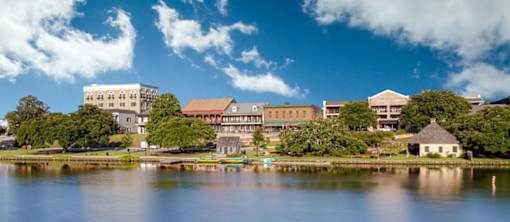 A large building sits on the shore of a lake.