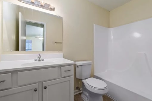 A white toilet sits next to a sink in a bathroom.