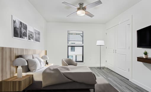 A bedroom with a large bed and a ceiling fan.