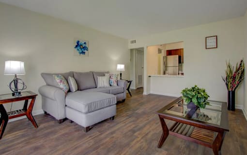 A living room with a grey couch and a wooden coffee table.