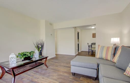 A living room with a grey couch and a wooden coffee table.