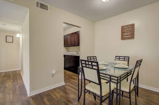 A dining room with a glass table and chairs.