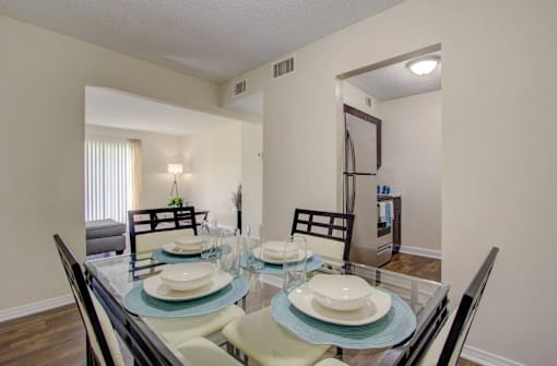 A dining room with a glass table and chairs.