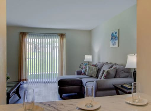 A living room with a grey couch and a wooden table.