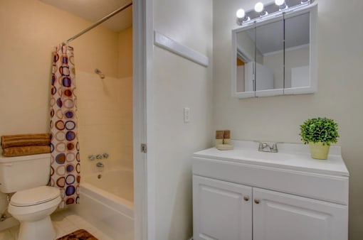 A white bathroom with a toilet, sink, and shower.