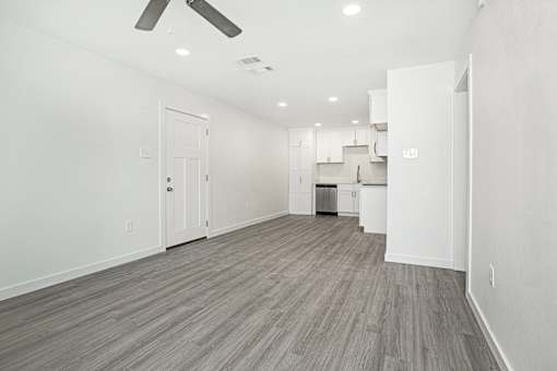 A spacious room with a ceiling fan and lighting fixtures.