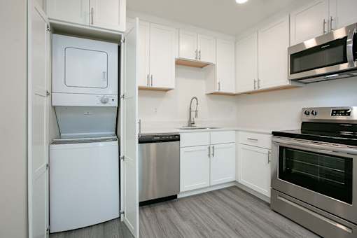 A kitchen with white cabinets and stainless steel appliances.