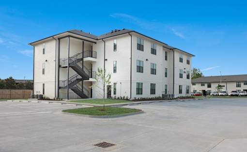 A white apartment building with a black and white staircase.