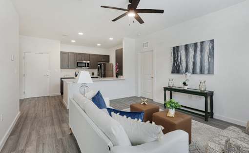 A living room with a white couch and a ceiling fan.