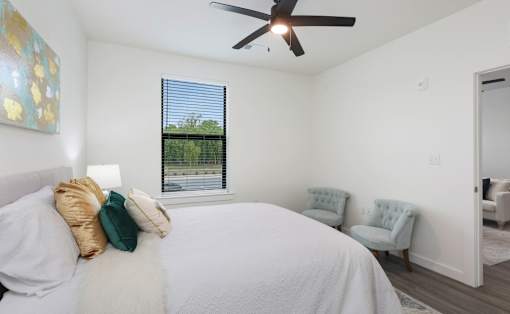 A bedroom with a large bed and a ceiling fan.