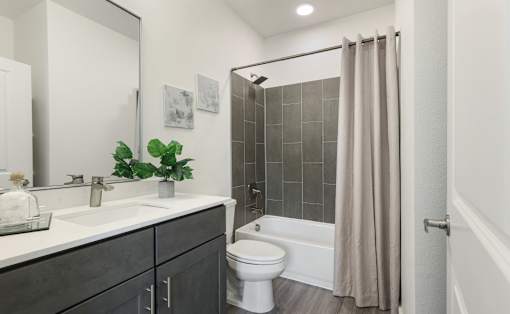 A bathroom with a white toilet and a shower with a beige curtain.