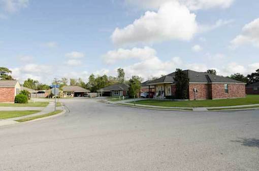A street view of a residential area with houses and a clear sky.