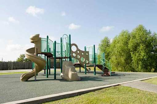 A playground with a slide, swings, and a climbing frame.