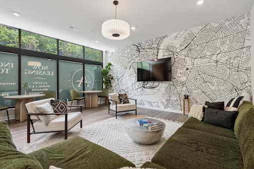 A living room with a large green couch and a map on the wall.