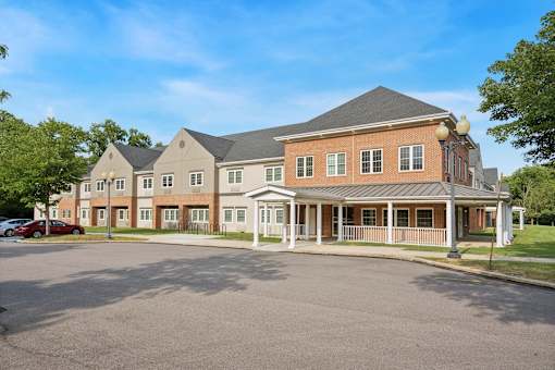 A large building with a parking lot in front at Roosevelt Commons Apartments, Philadelphia, PA