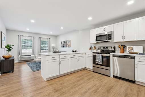 A modern kitchen with white cabinets and stainless steel appliances at Roosevelt Commons Apartments, Pennsylvania