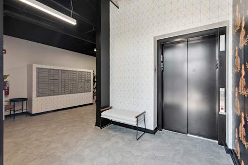 A room with a black door and a white bench.