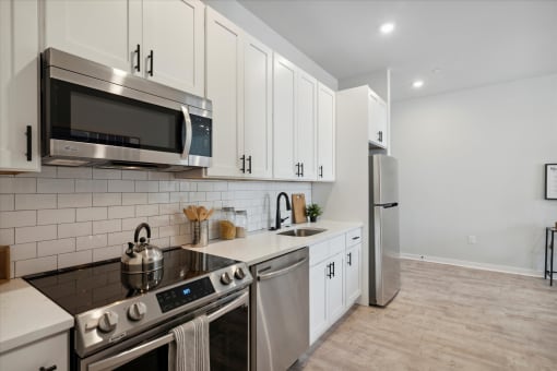 a kitchen with white cabinets and stainless steel appliances