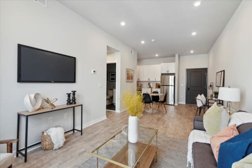 a living room with a tv and a kitchen in the background