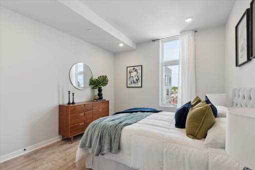 a bedroom with a large bed and a dresser with a mirror