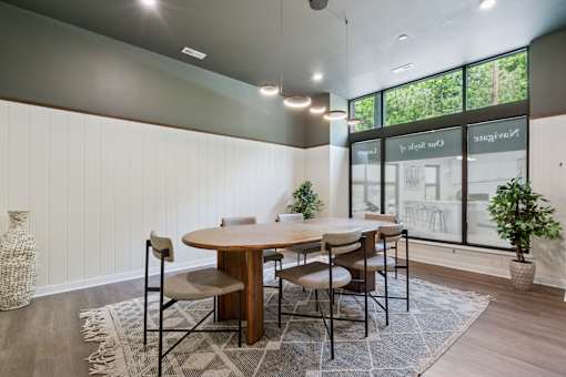 A dining room with a round table and chairs.