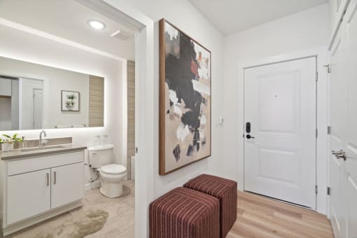 a bathroom with a toilet and a sink and a painting on the wall