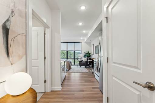A hallway with white doors and a wooden floor.