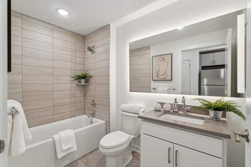 A bathroom with a white tub, toilet, and sink.