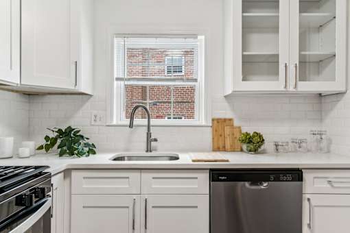A modern kitchen with white cabinets and a stainless steel dishwasher.
