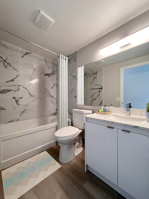 A white toilet sits in a bathroom with marble tiles.